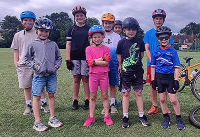 A group of children wering cycle helmets standing for a photo