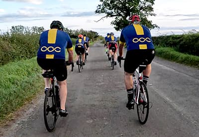 A group of cyclists riding together on a country road