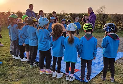 A group of children listening to a Scout leader