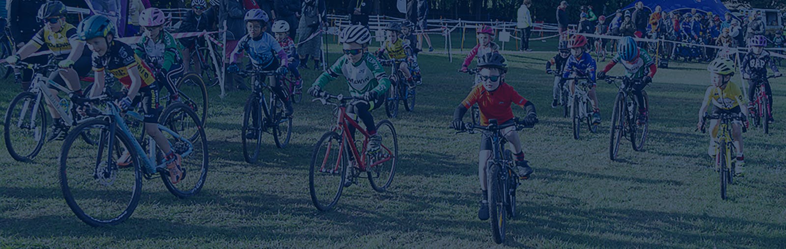 Young cyclists starting a sportive. They are cycling on a grass course.